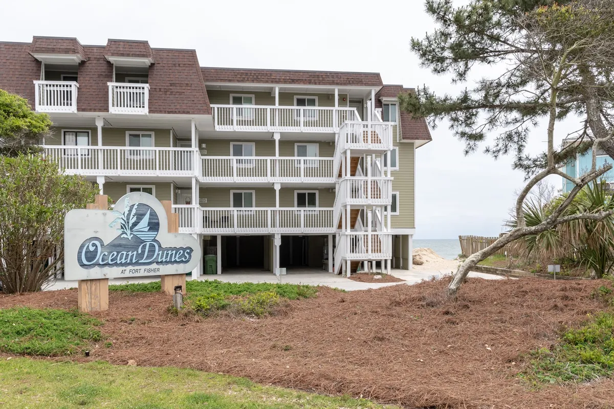 This image shows the welcoming Ocean Dunes sign, entrance stairs, and private balconies of the resort complex, with easy access to the beach just beyond. It highlights the inviting atmosphere and proximity to the shoreline.