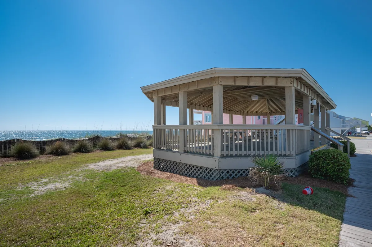 The photo features a pavilion structure with open views of the ocean and thoughtful landscaping. The space is ideal for picnics, gatherings, and enjoying the sea breeze, connecting visitors to the coastal environment.